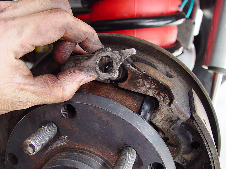 11. Again, using a pair of vice grips, clamp onto the brake shoe return spr...